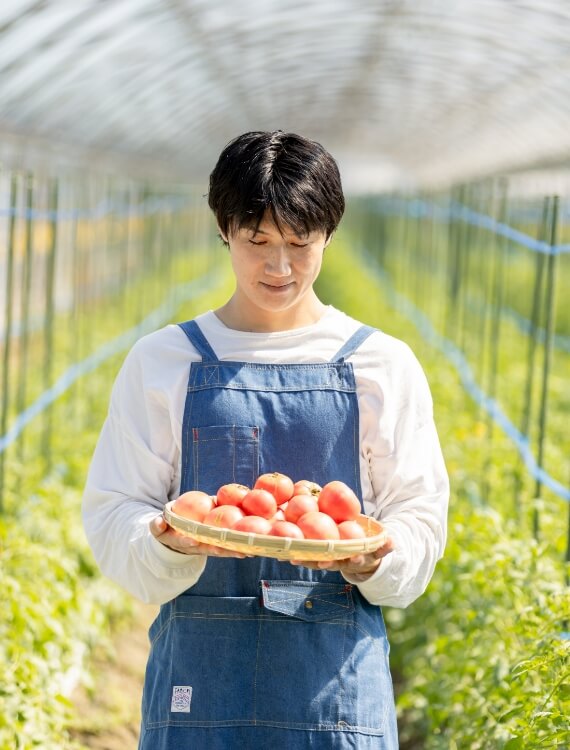 トマトを手にするトマトリンク株式会社 代表取締役 中村優貴